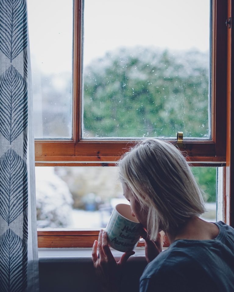 femme tasse de café à la fenêtre slow life