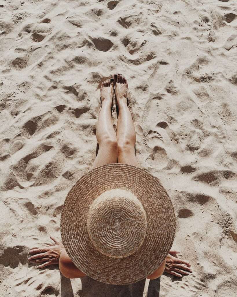 femme chapeau plage bain de soleil préparer sa peau au soleil
