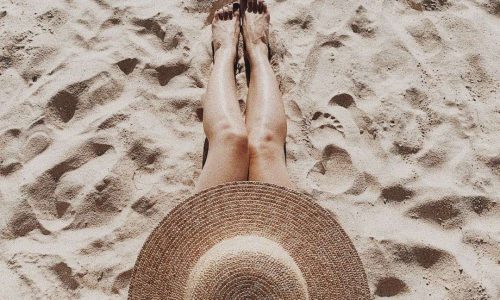 femme chapeau plage bain de soleil préparer sa peau au soleil